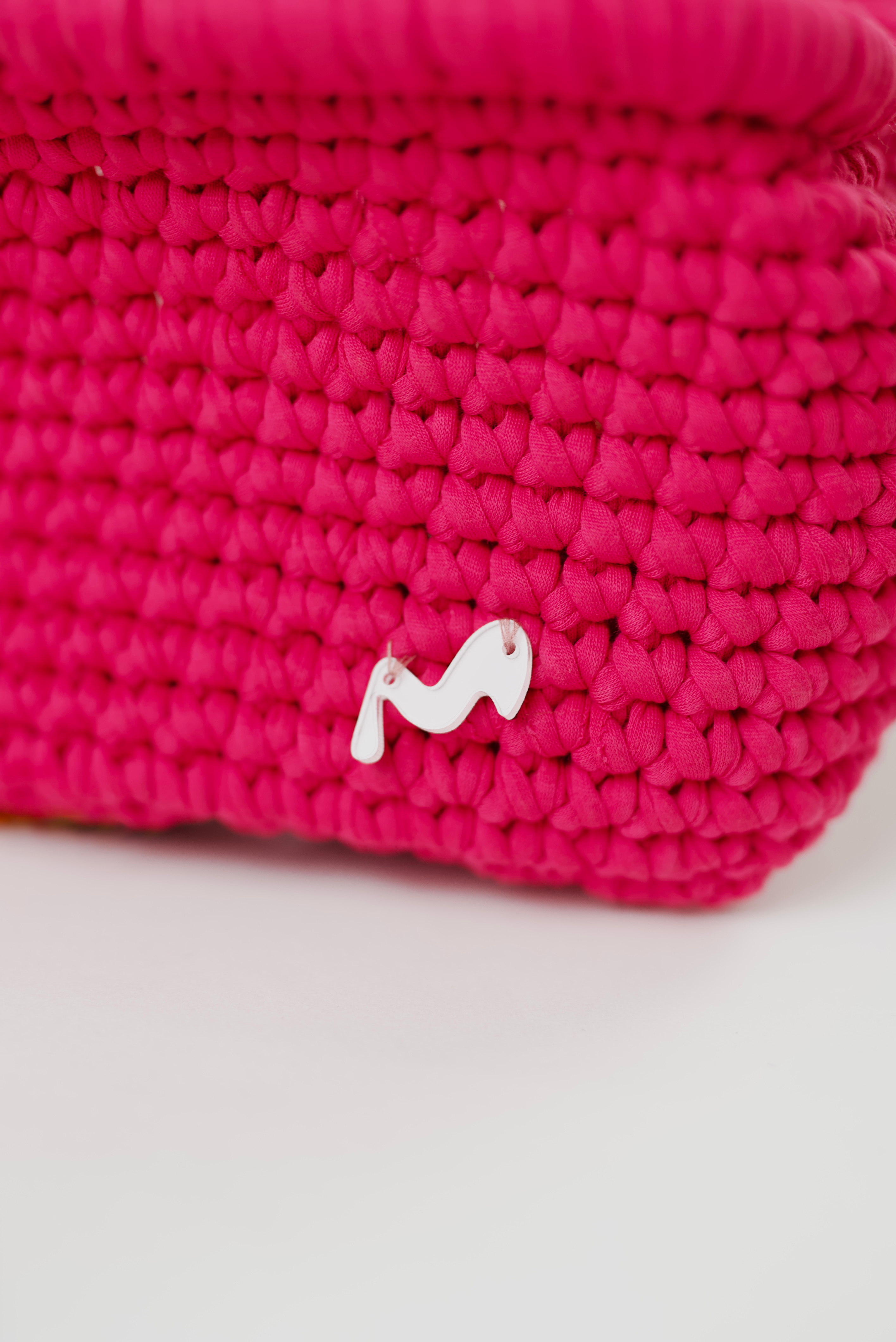 My -M-Advance Close-up of a pink woven basket with a white logo