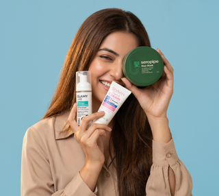 Woman holding hair and skin care products 